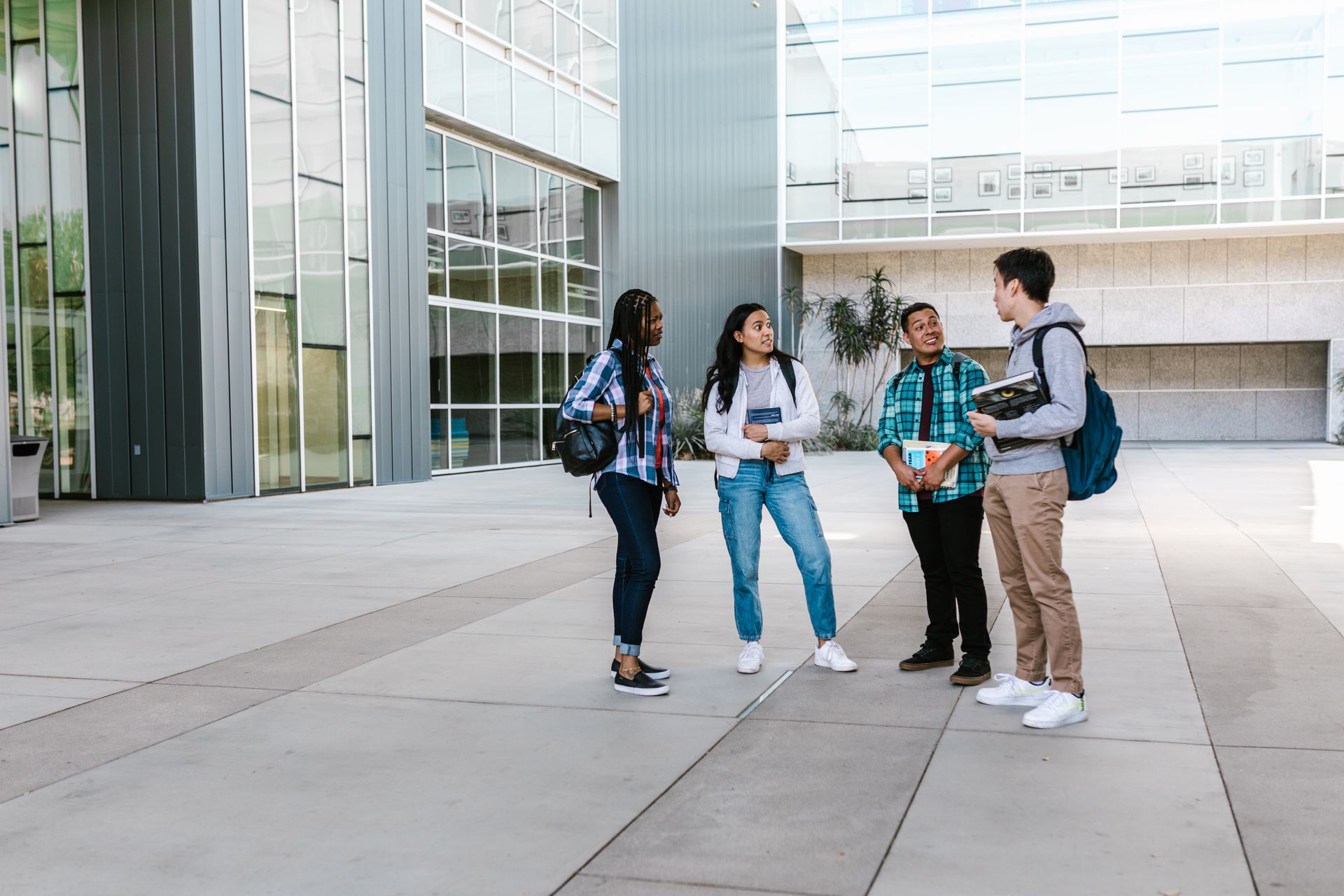 Estudiantes conversando afuera del campus de una universidad