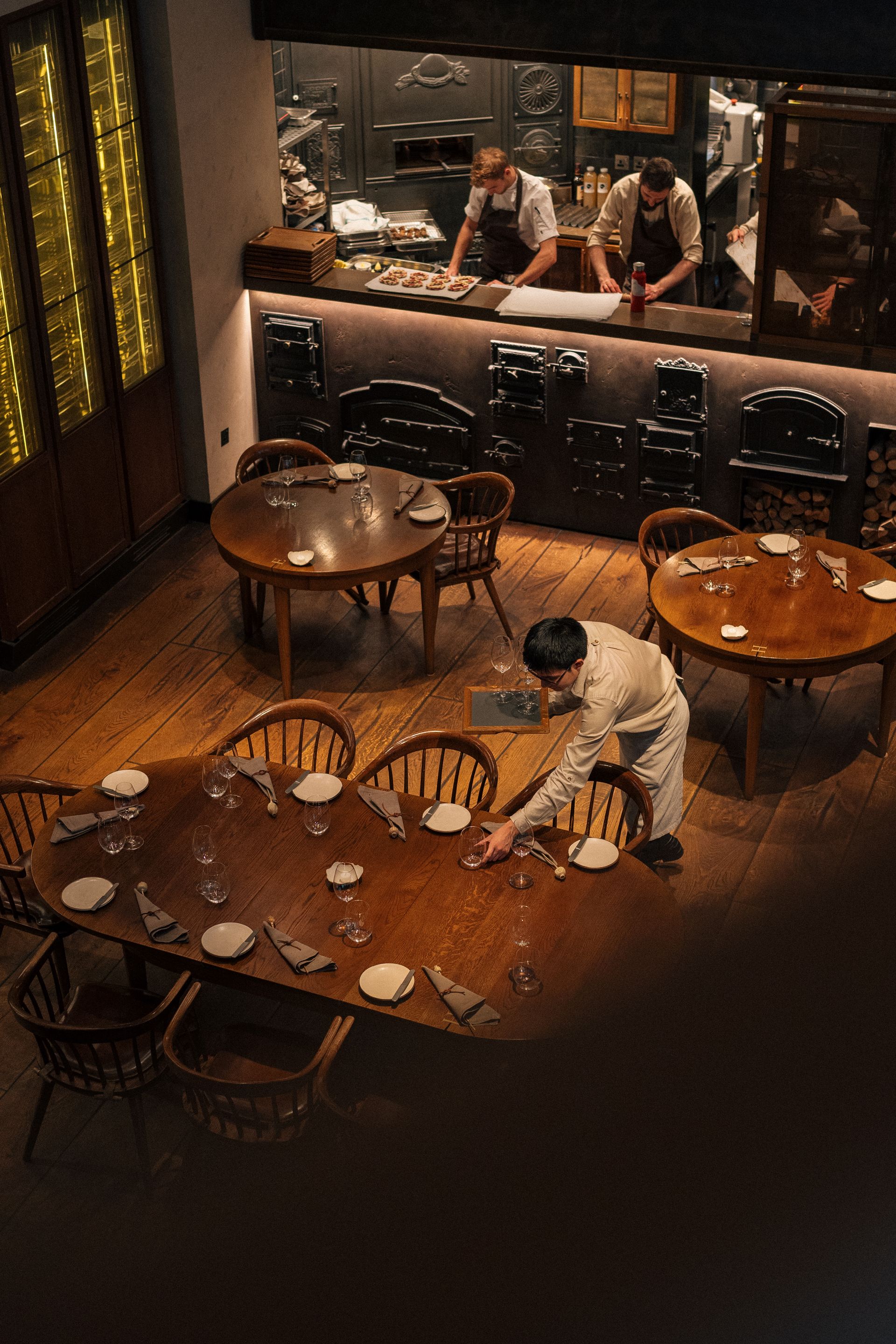 Salón de restaurante visto desde arriba con el personal alistando las mesas